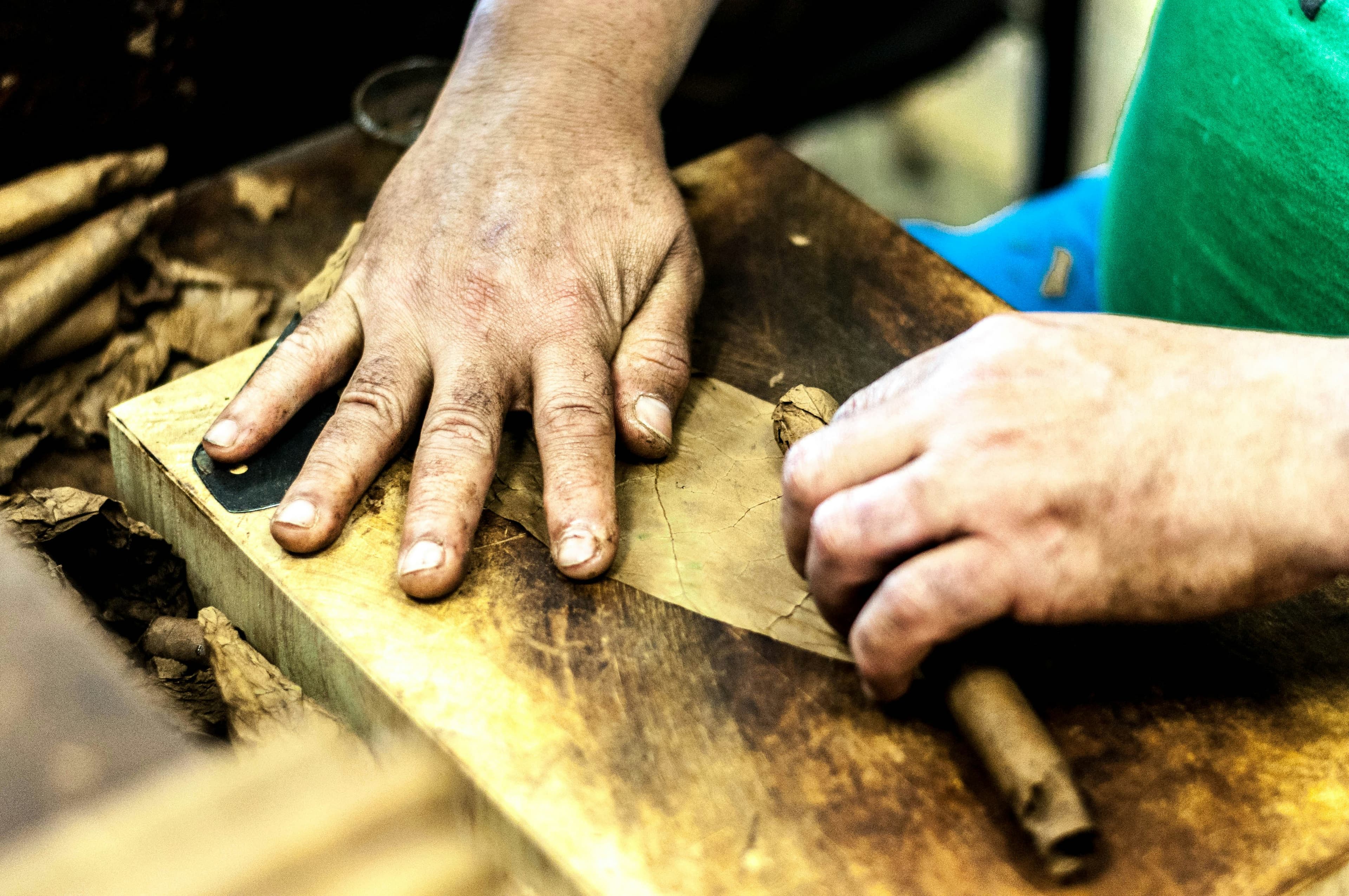 A maker finishing a piece of wood by hand